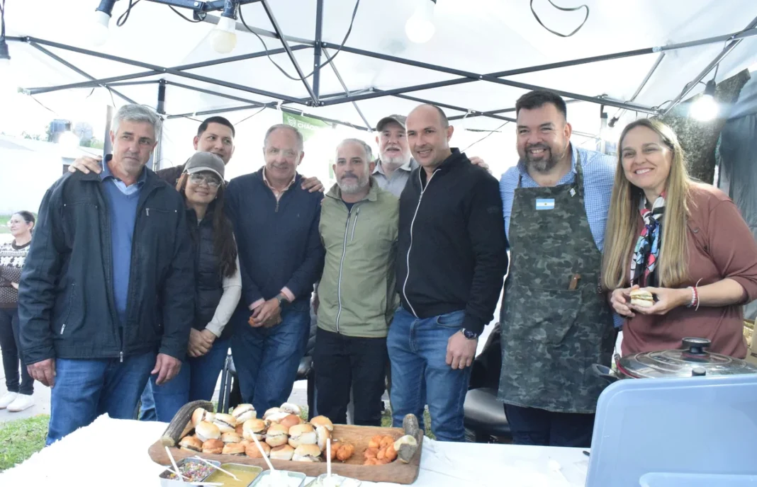 Productores y autoridades junto a una mesa con torrejas de mandioca en la Expo Frutihortícola de Colonia Benítez.