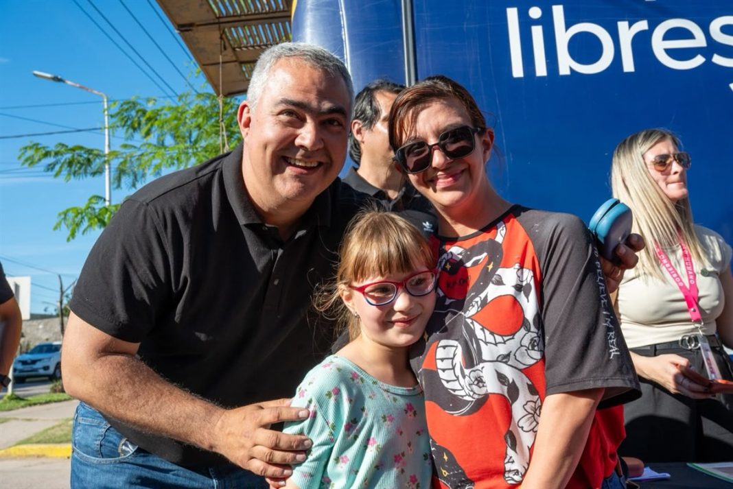 Una niña con anteojos posa junto a dos adultos durante el operativo Ver para Ser Libres en Chaco