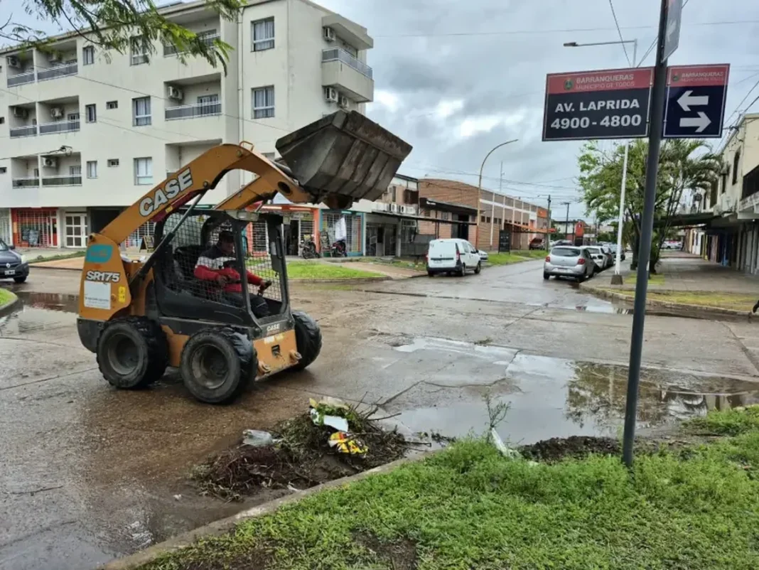 Máquina municipal retira restos de poda de un desagüe en una calle de Barranqueras