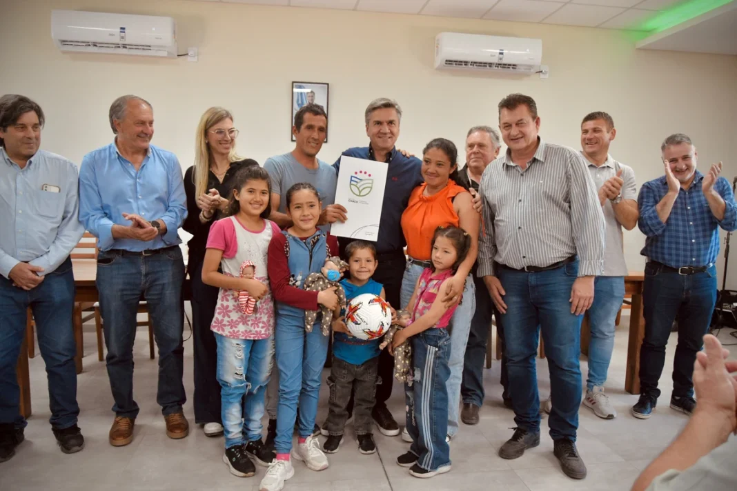 Entrega de documentación a una familia durante el acto en Castelli