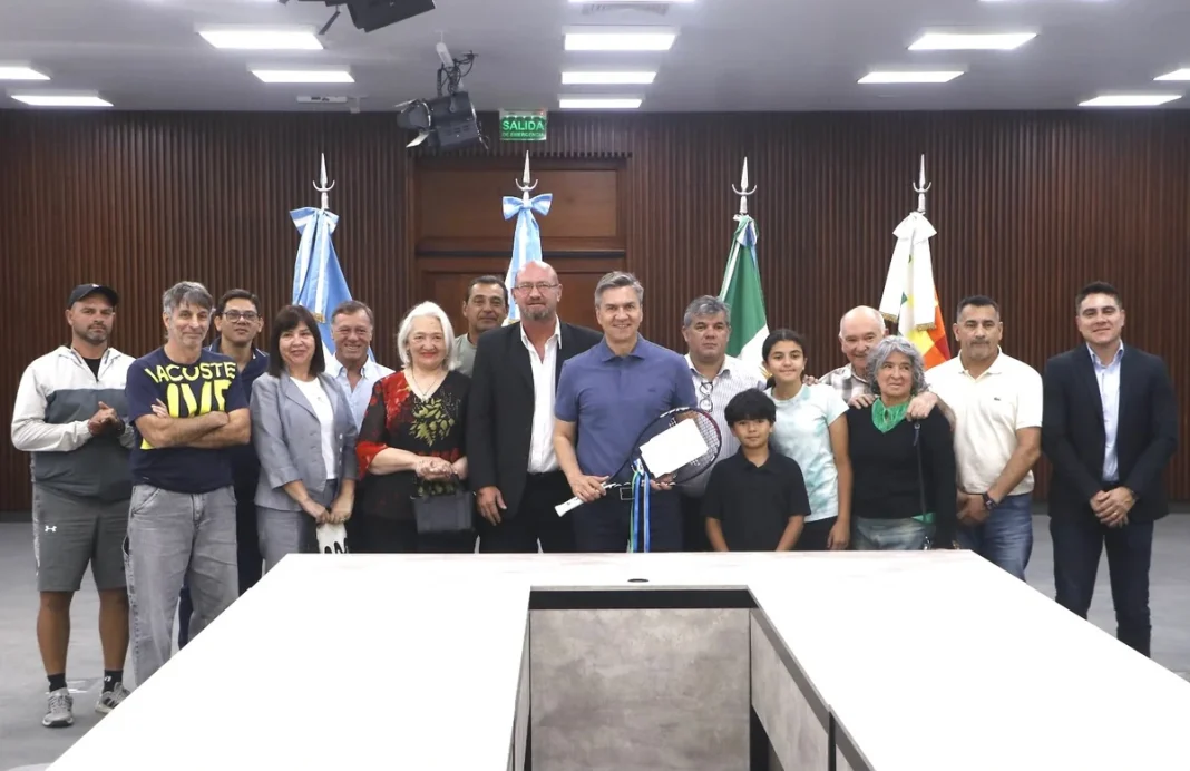 Integrantes de la Fundación Chaco Tennis posan con una raqueta durante la firma del comodato