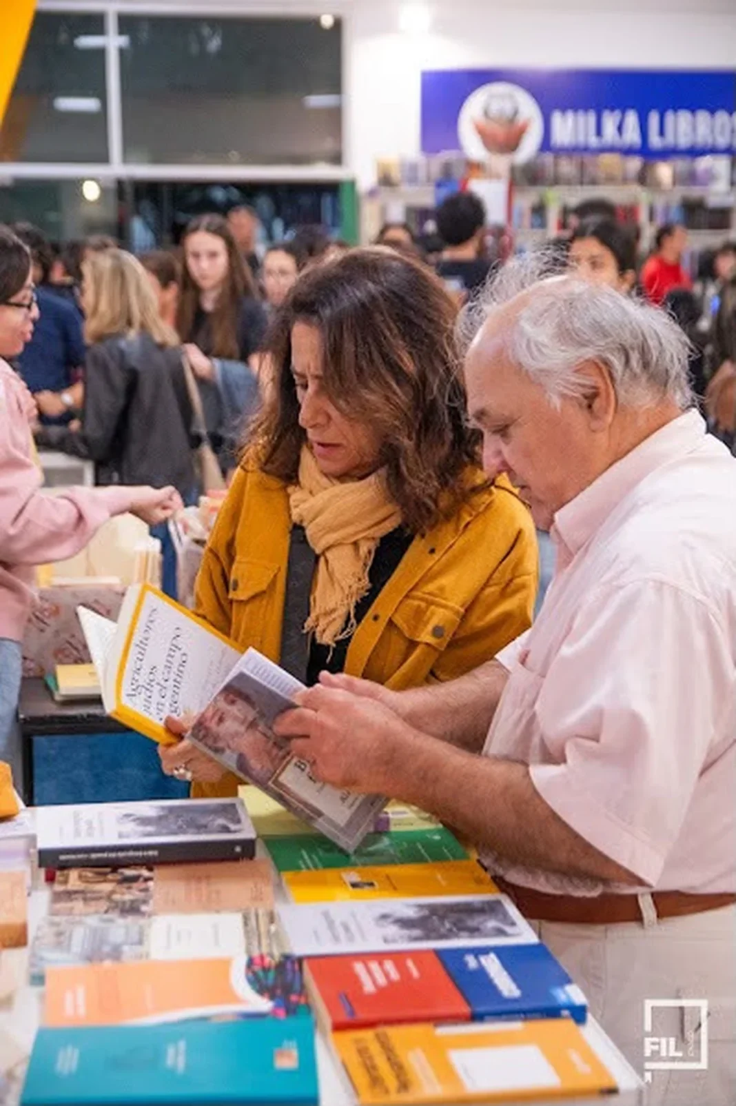 Una mujer y un hombre revisan un libro en un stand de la Feria Iberoamericana del Libro Chaco.