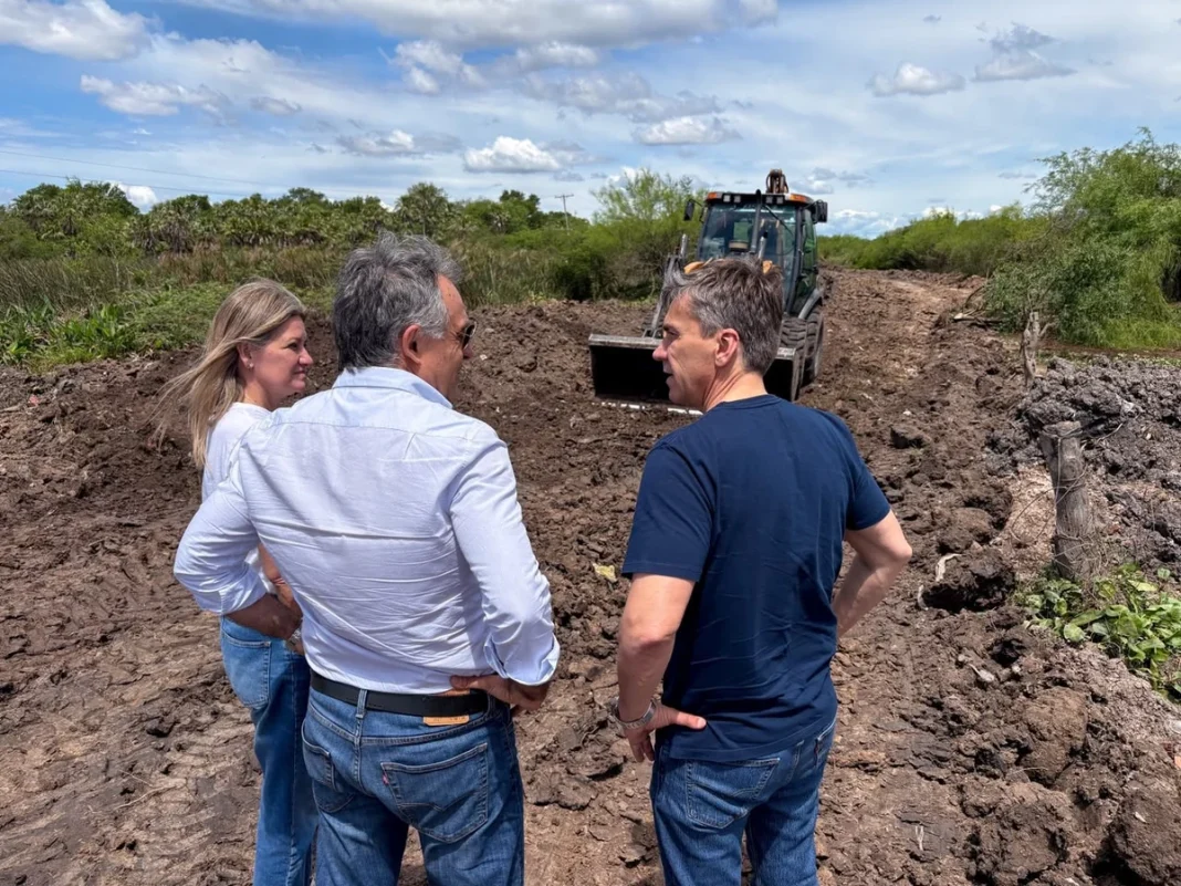 Funcionarios supervisan la ampliación del lago compensador junto a una retroexcavadora