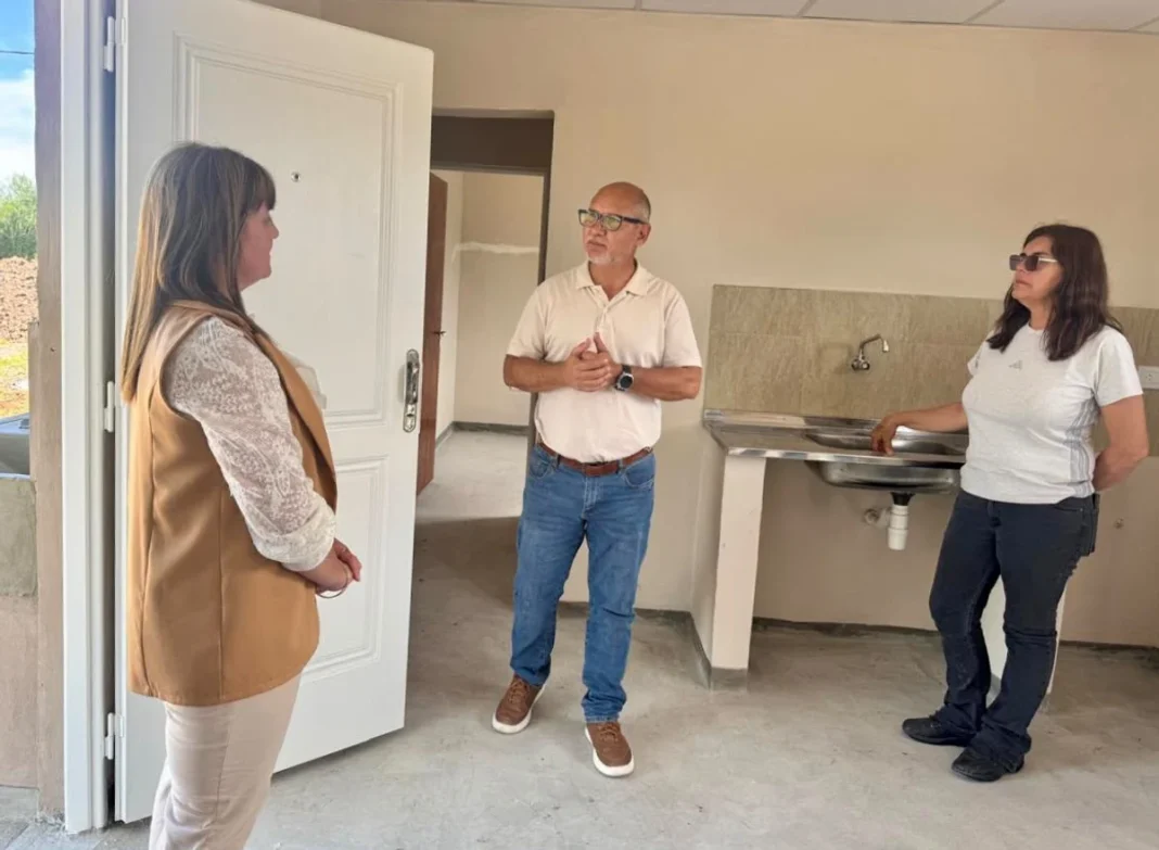 Tres personas recorren el interior de una vivienda en Pampa Almirón