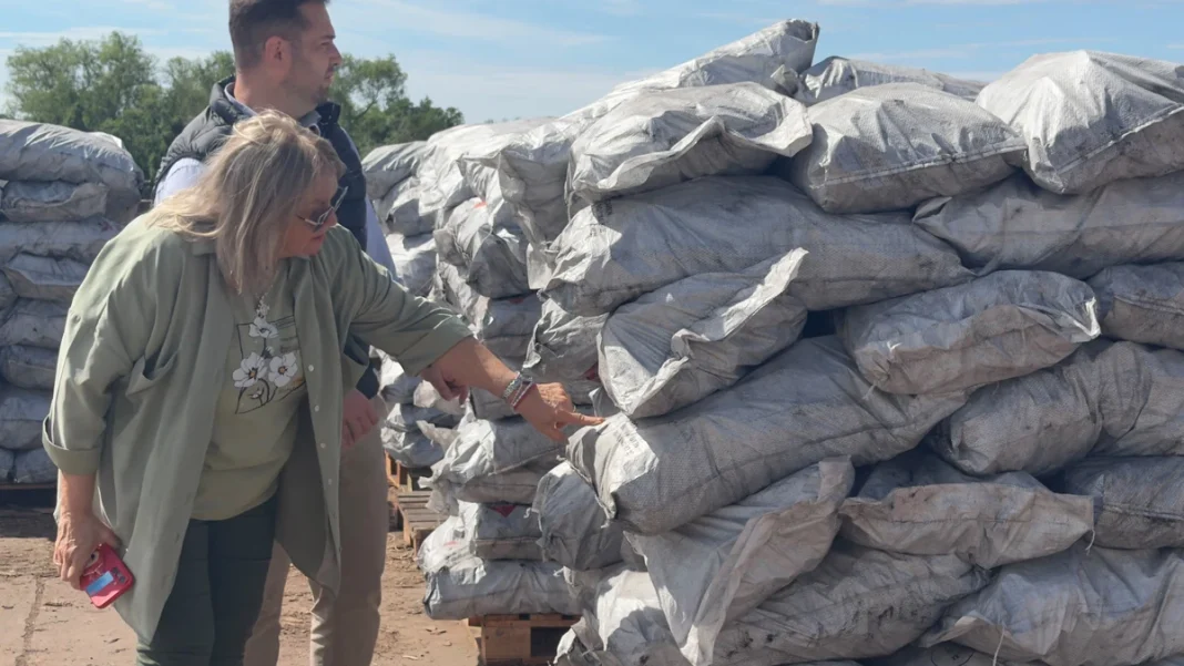 Dos personas junto a bolsas de carbón vegetal en el Puerto Barranqueras